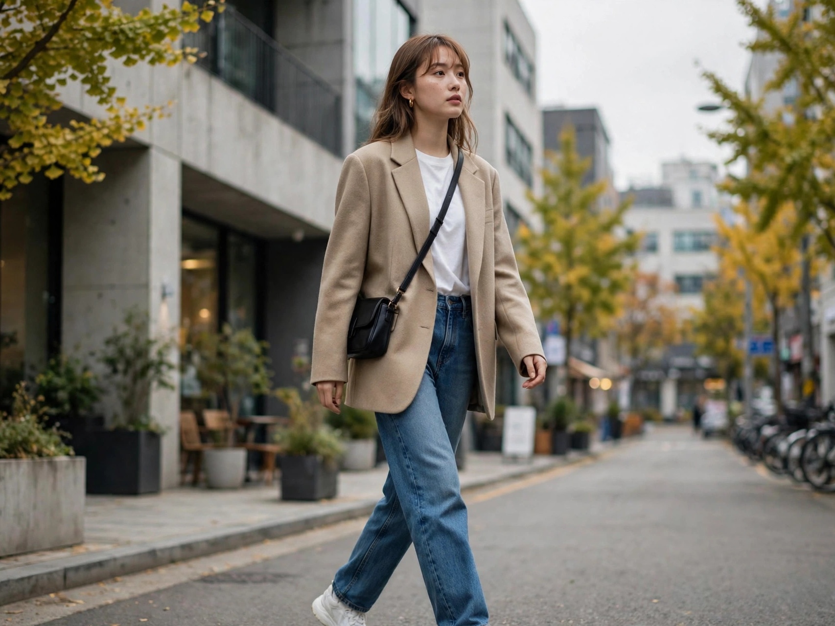 Woman wearing Korean fashion outfit ideas — oversized blazer and jeans in Seoul street style