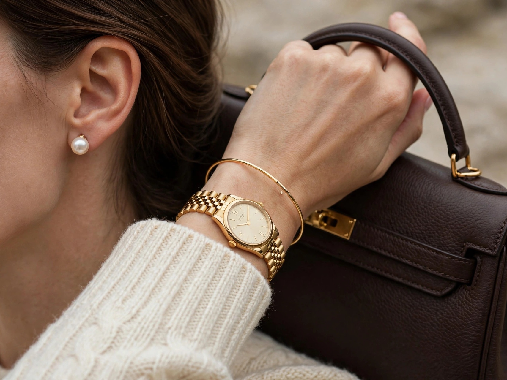 Woman in refined old money aesthetic outfit with pearl stud earrings and structured leather handbag